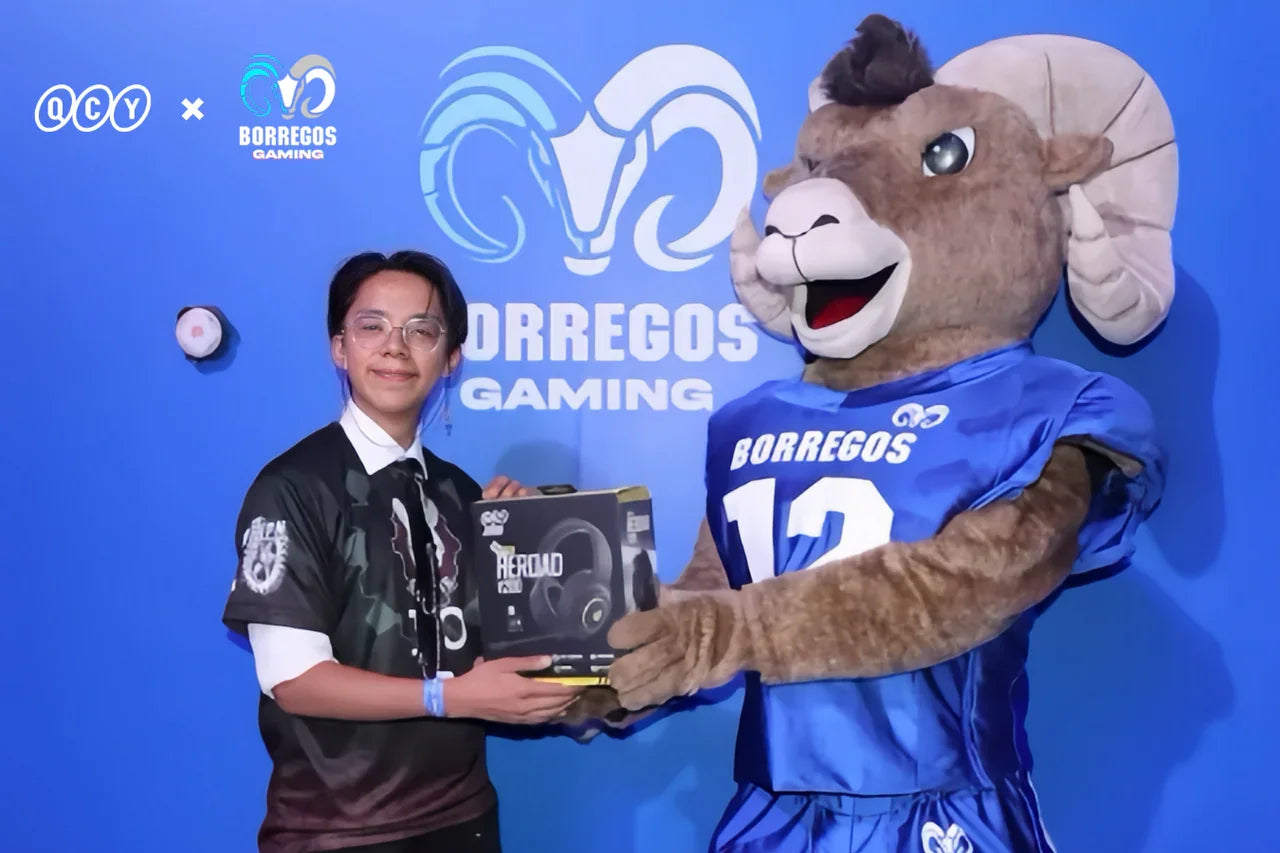 Person receiving QCY HEROAD gaming headphones box from Borregos Gaming mascot at event