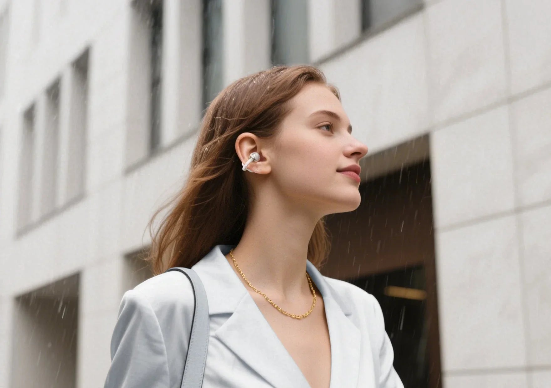 Woman wearing wireless earbuds in rain, enjoying immersive sound outdoors