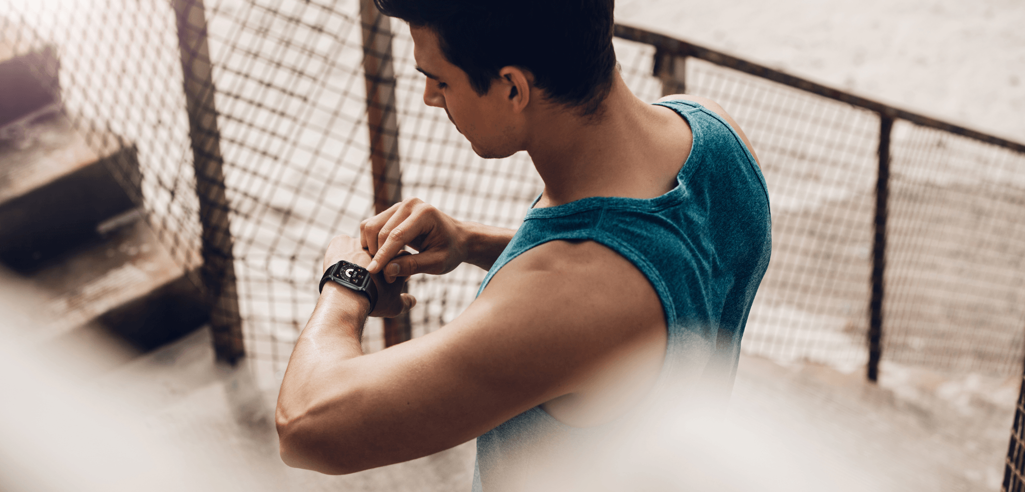 Man checking smartwatch during workout, fitness tracker on wrist, athletic gear