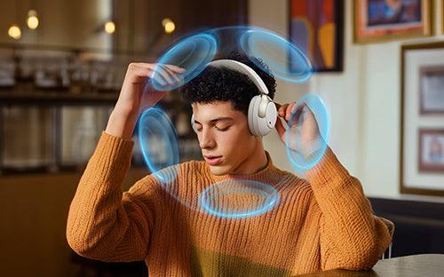Man wearing white wireless headphones with immersive sound waves, enjoying premium audio experience