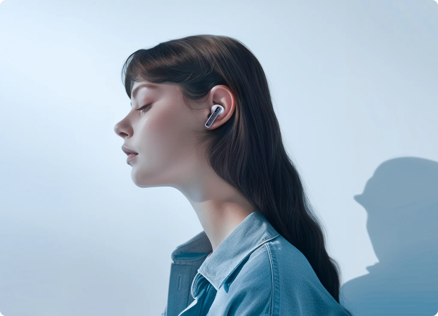 Woman wearing white wireless earbuds in side profile