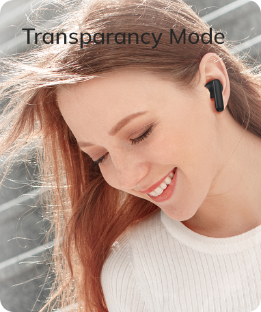 Woman wearing black wireless earbud with transparency mode, smiling outdoors.